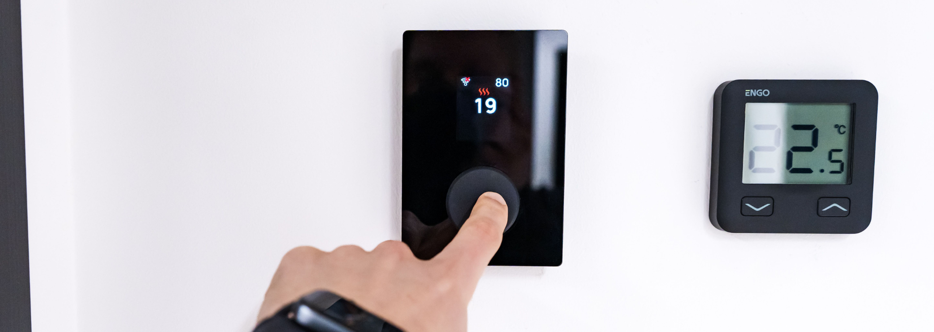 Picture of someone adjusting the thermostat. 