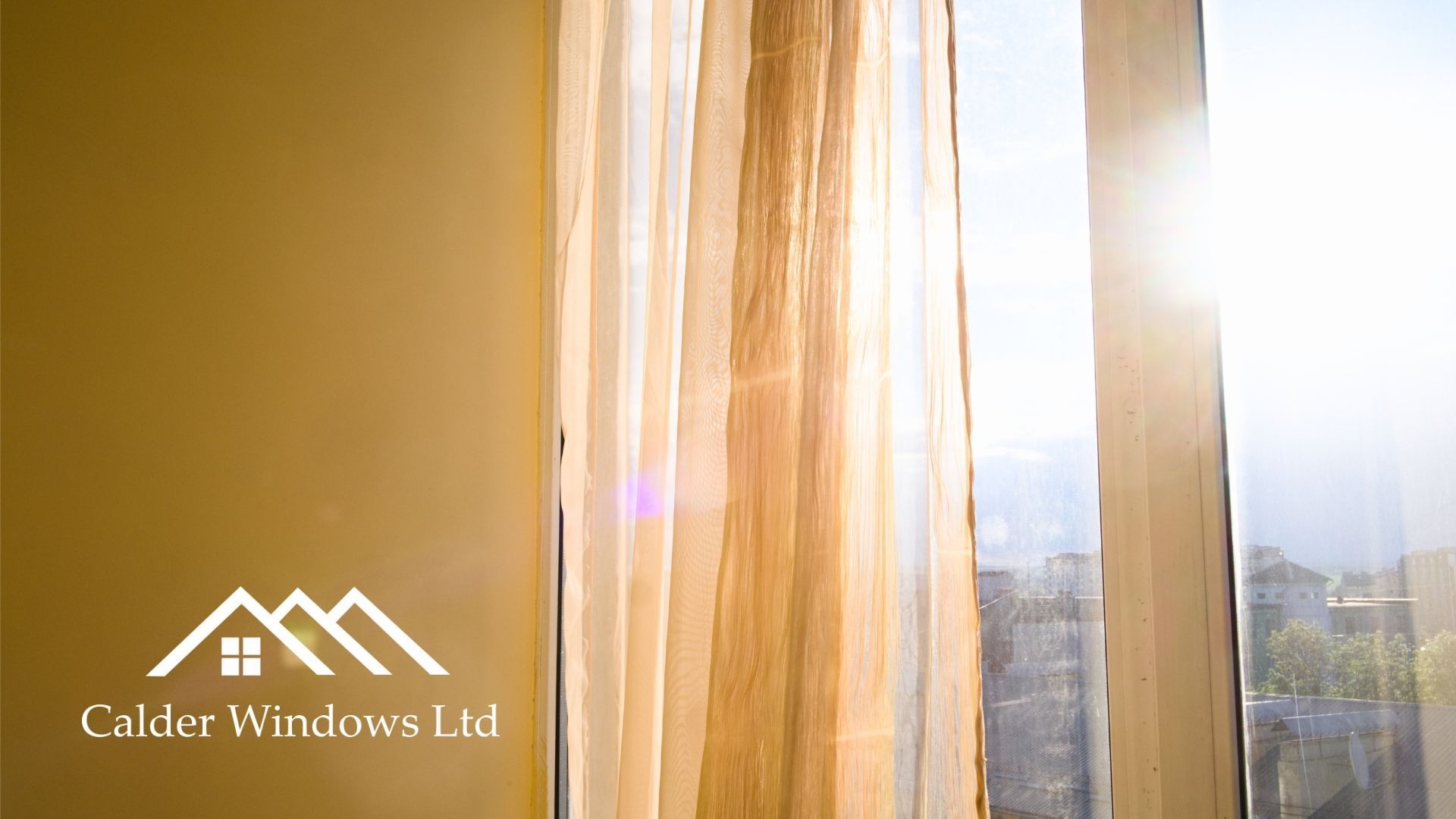 Sunlit curtains by a window with a building logo in the lower left corner