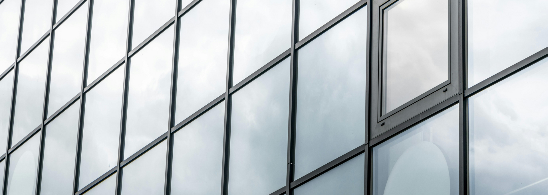 Reflective glass office building facade with gray window panels