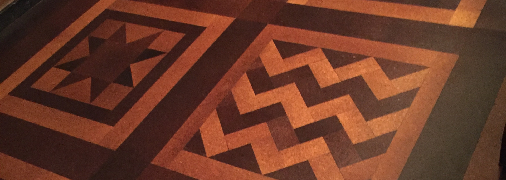 Geometric tiled floor with brown, orange, and black star and zigzag patterns