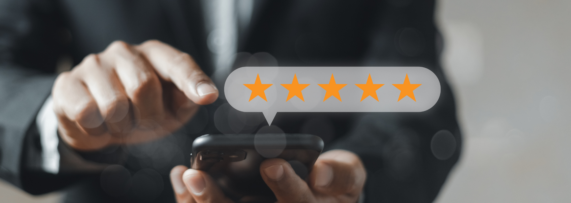 Hand holding a smartphone while tapping a 5-star rating on a glowing review screen