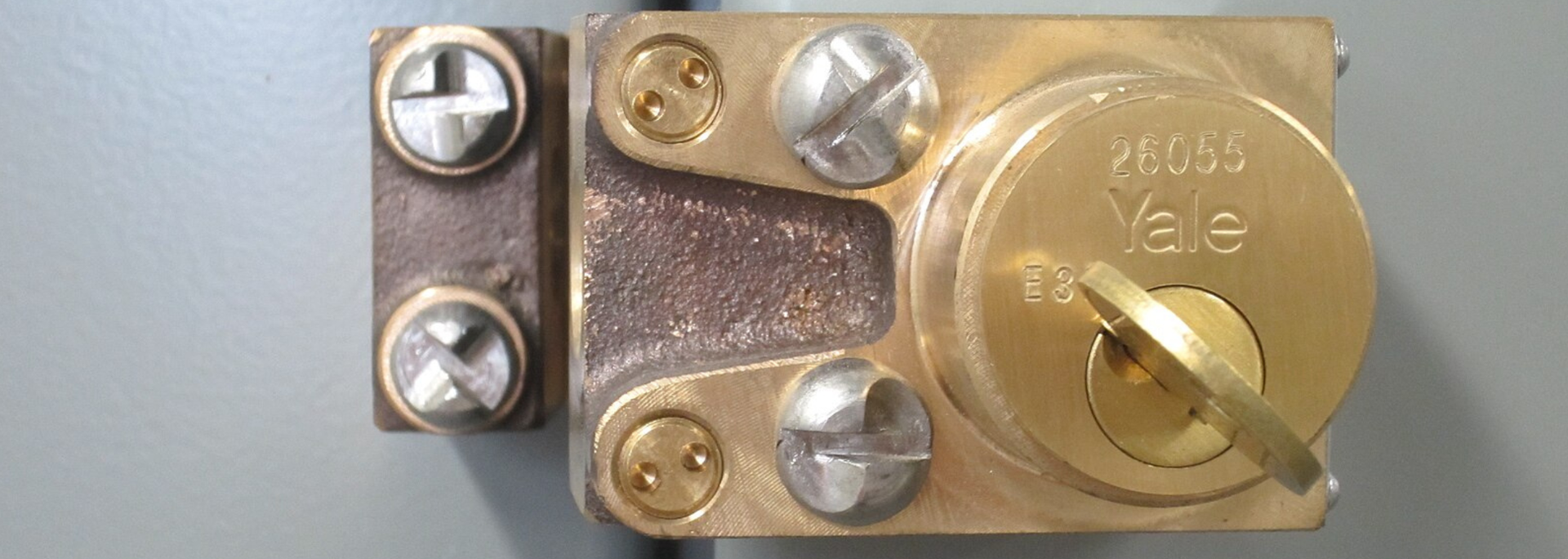 Close-up of a brass electrical connector with screws and a round terminal on a white background