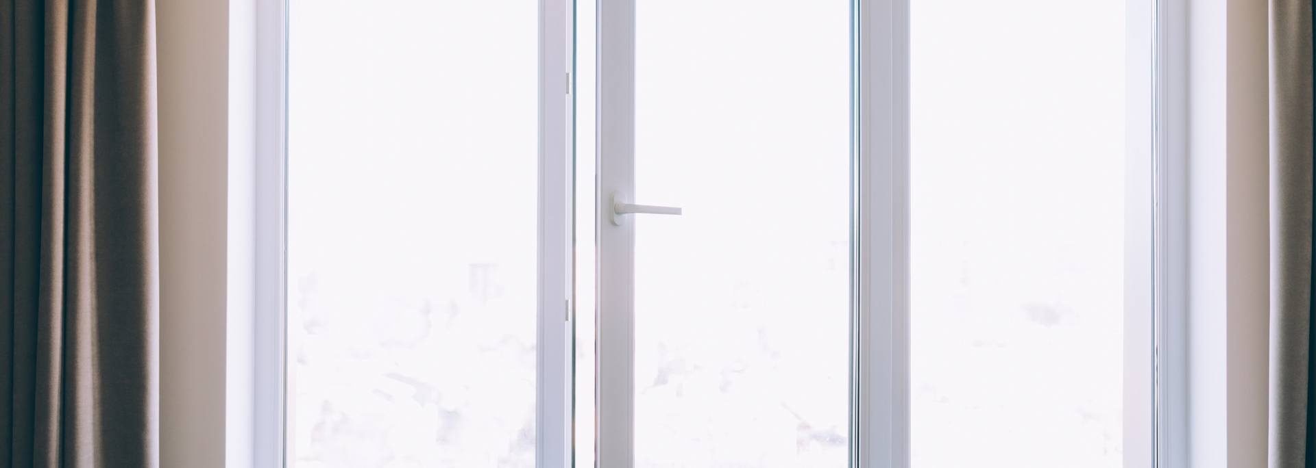 Bright window with white sheer curtains and pale daylight filtering through the panes