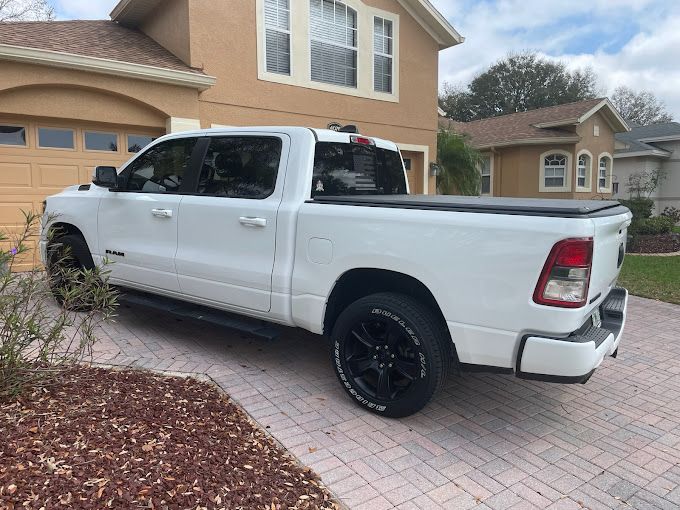 A white truck is parked in front of a house.