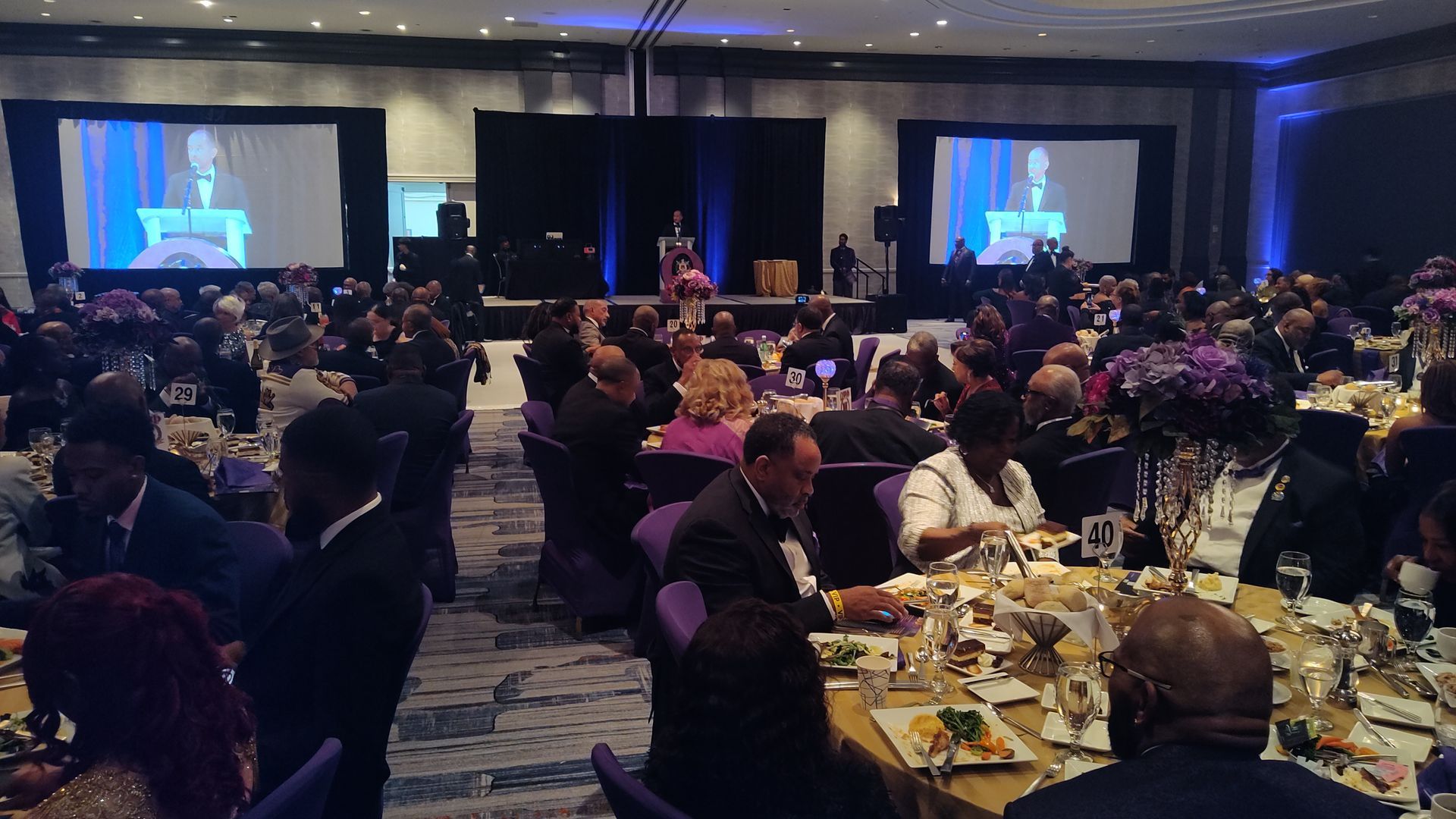 A large group of people are sitting at tables in a large room