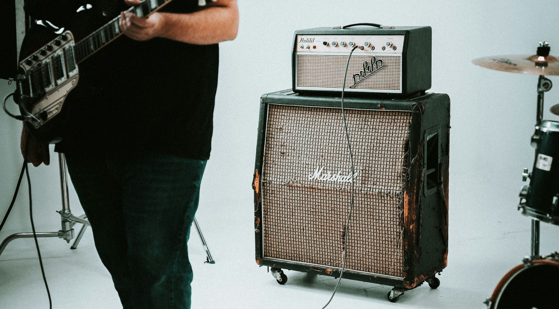 a man is playing a guitar in front of a marshall amplifier