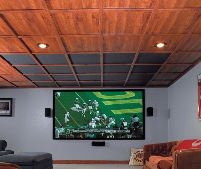Home theater with a large screen, wooden ceiling, and football game playing.