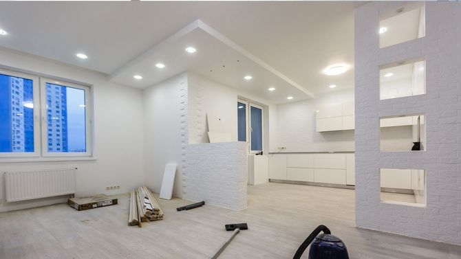 Gray wall with patches of white filler and a small window on the right.