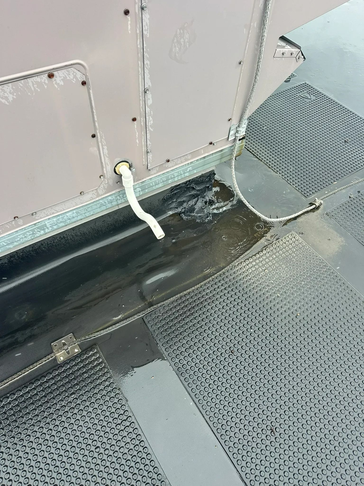 Wet bus aisle with patterned seats and a white hand strap hanging by the door