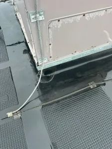 Gray utility boxes and cables on a textured metal surface outdoors.