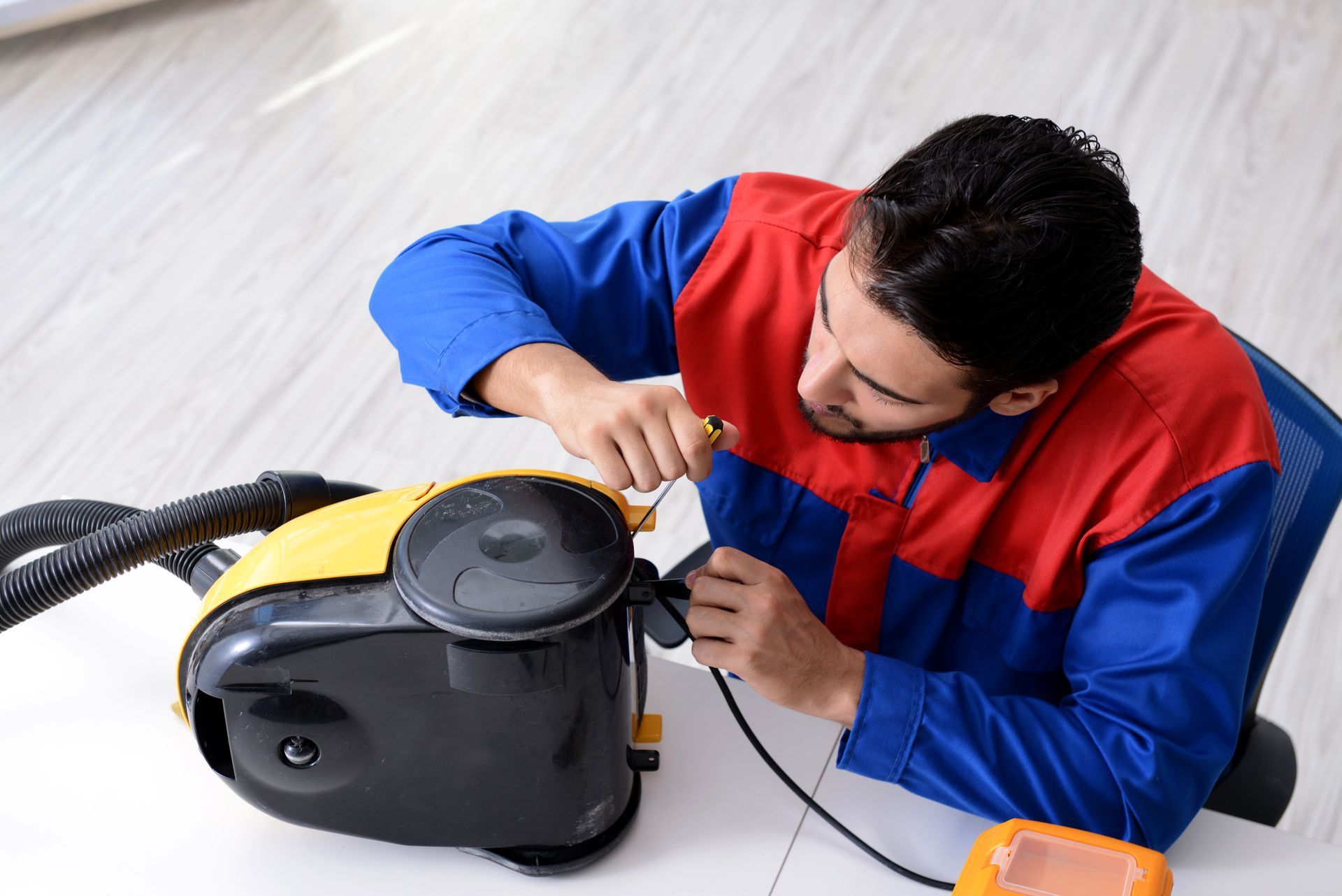 A Man Is Fixing a Vacuum Cleaner