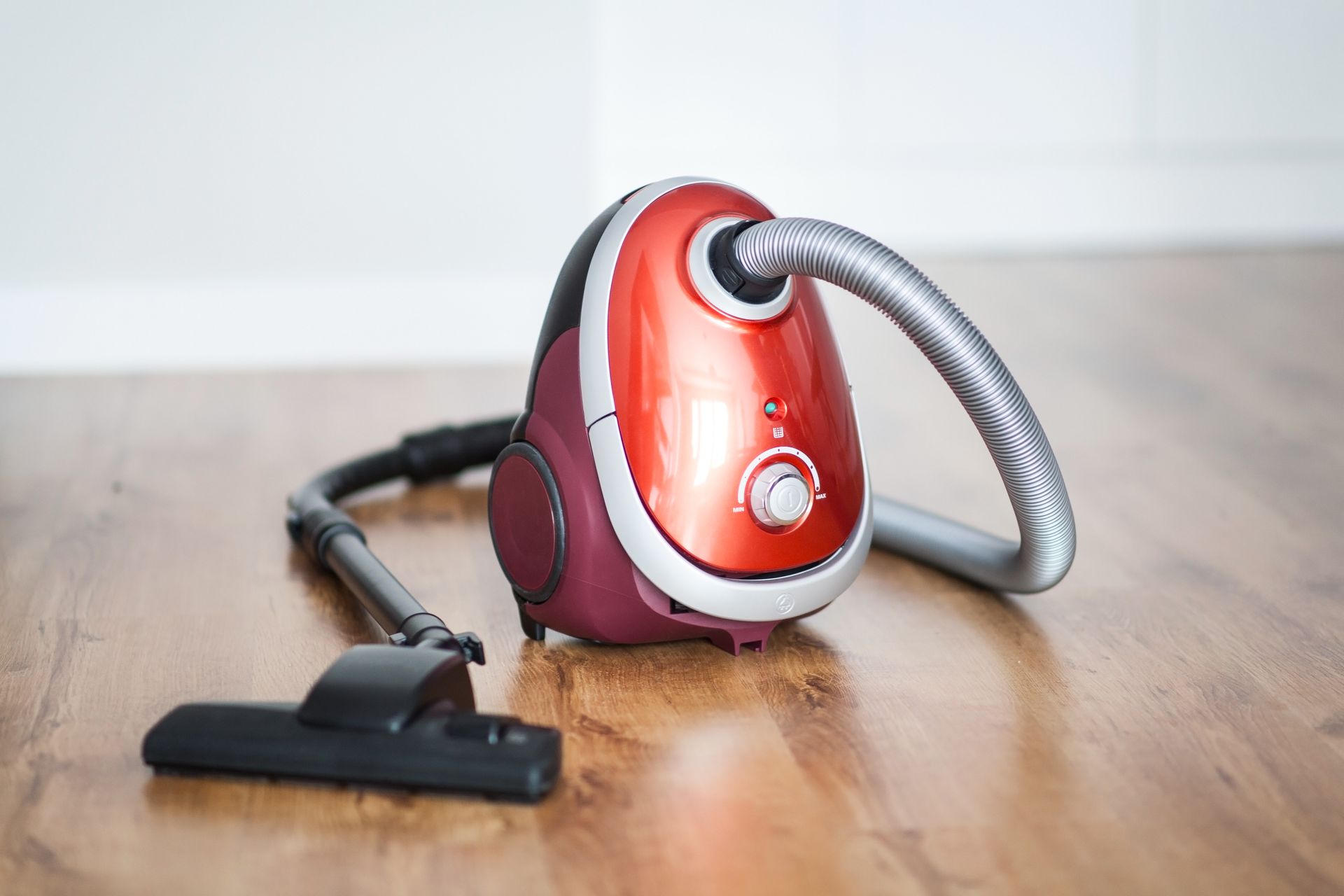 A Red Vacuum Cleaner Is Sitting on A Wooden Floor