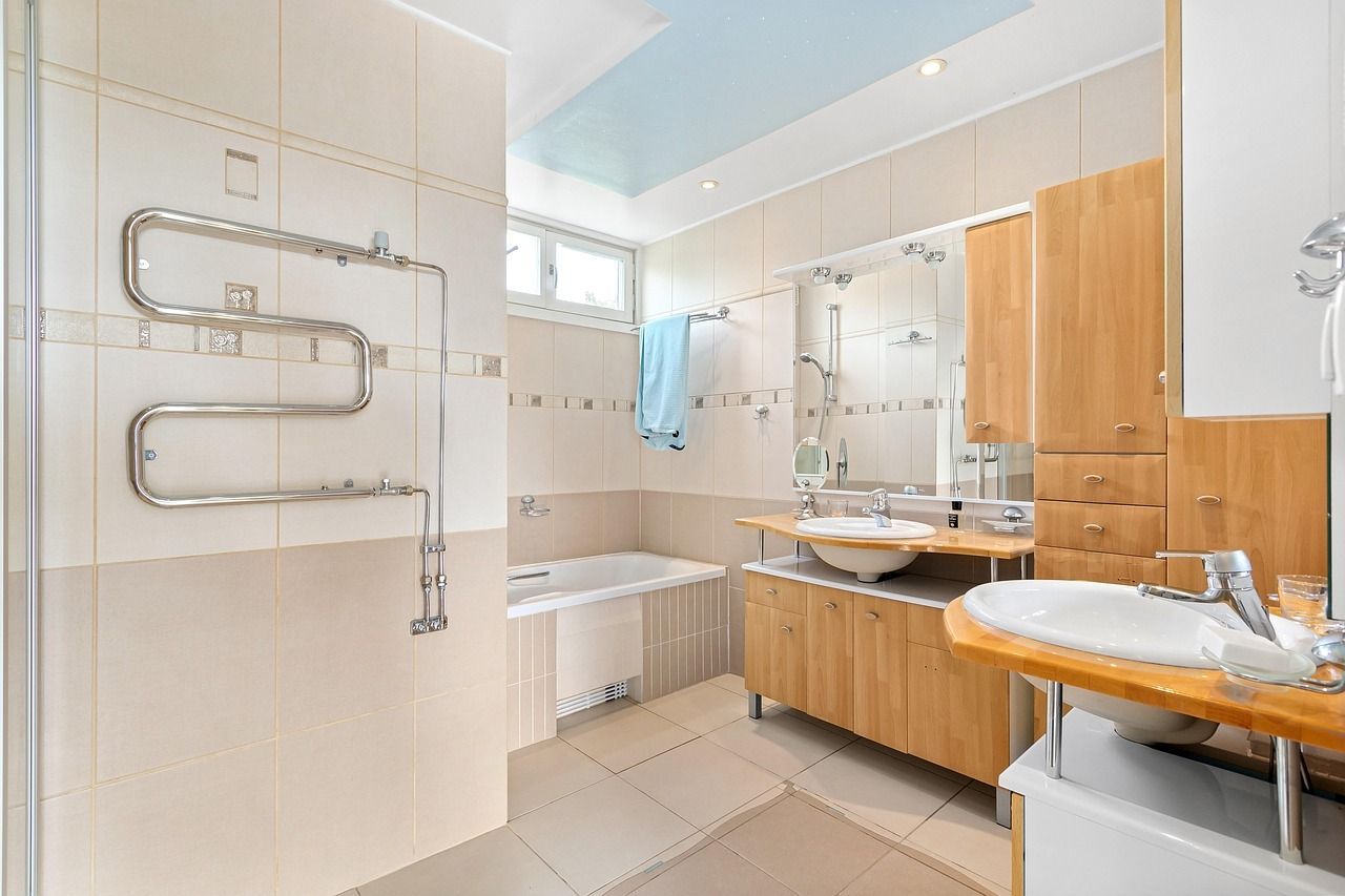 A white tiled open concept shower with black accessibility handles