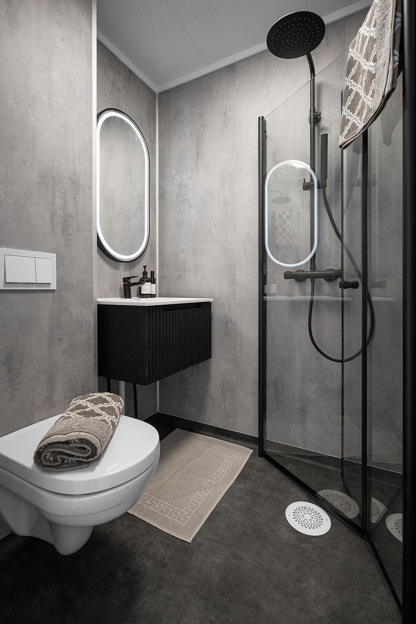 A clean modern white marbled bathroom with a standalone tub and gold trimmings
