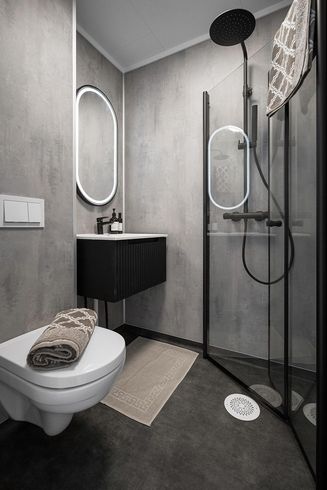 A sleek light brown open-concept bathroom with backlit mirror, standalone tub, and multiple canned lights