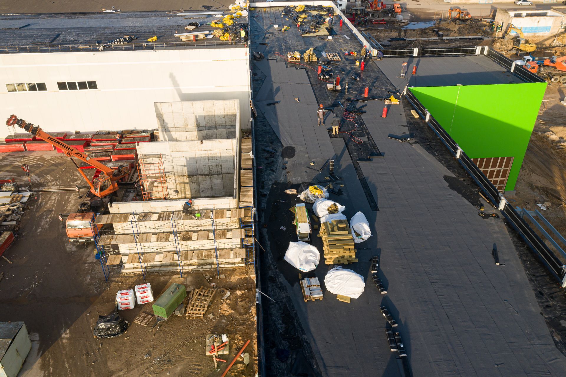 Commercial roofing installation on a large industrial building rooftop.