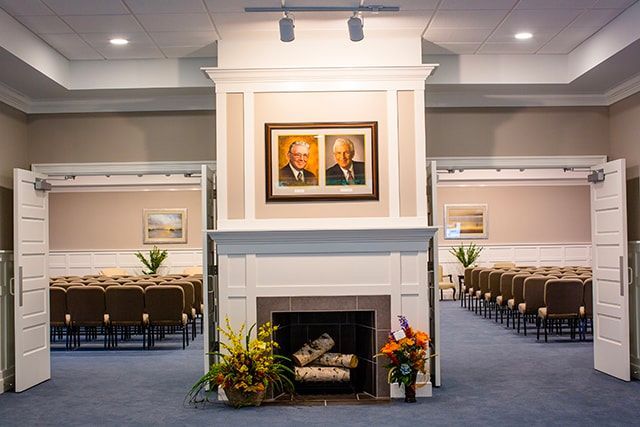 a room with a fireplace and two pictures on the wall