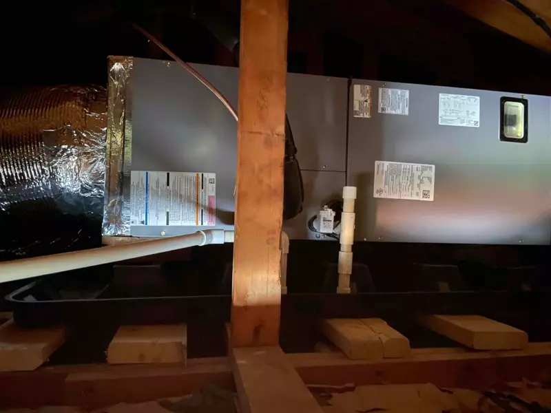 Central AC air handler installed in an attic space with insulated ventilation ductwork
