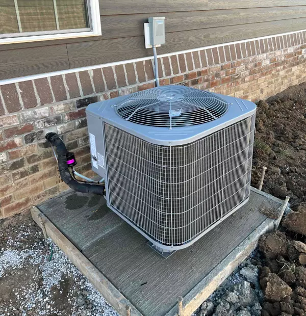 Outdoor air conditioning unit professionally installed with refrigerant lines and electrical connections