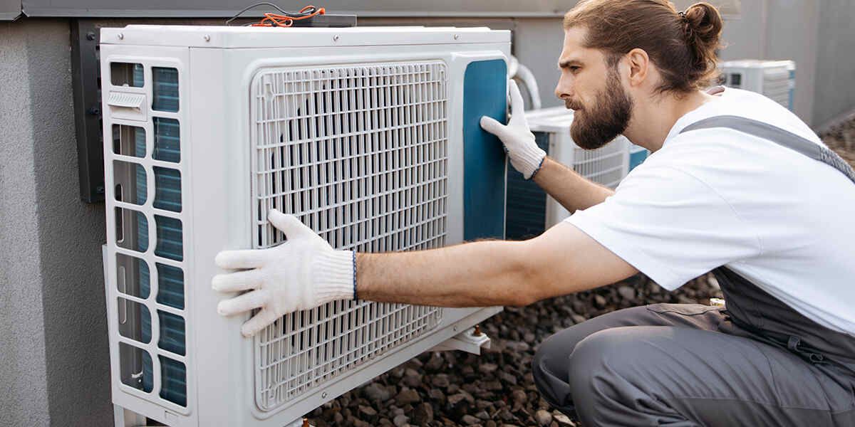 Technician cleaning an air conditioner coil on an outdoor unit in Berea, KY