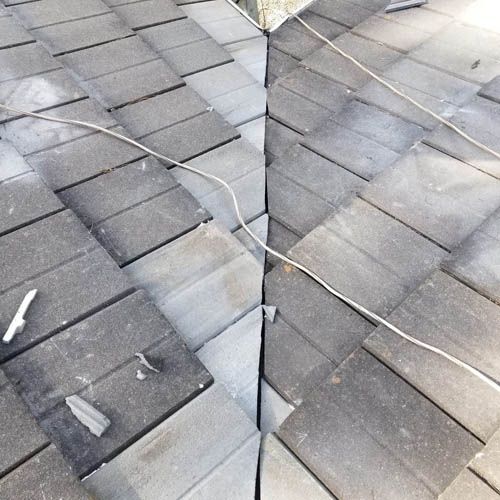 A roof with a lot of tiles and a wire hanging from it.