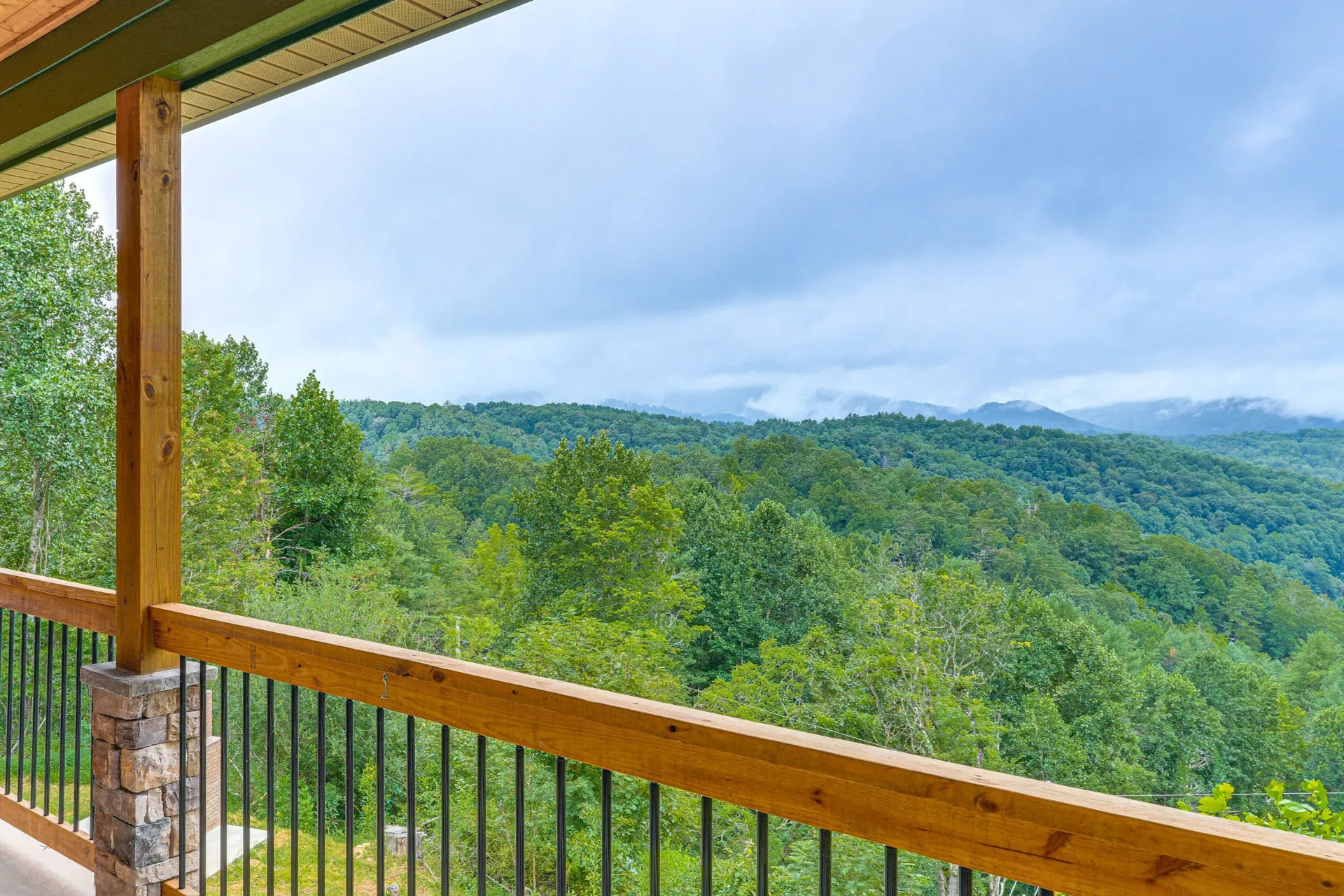 Mountain view from a wooden deck with pine trees at sunset