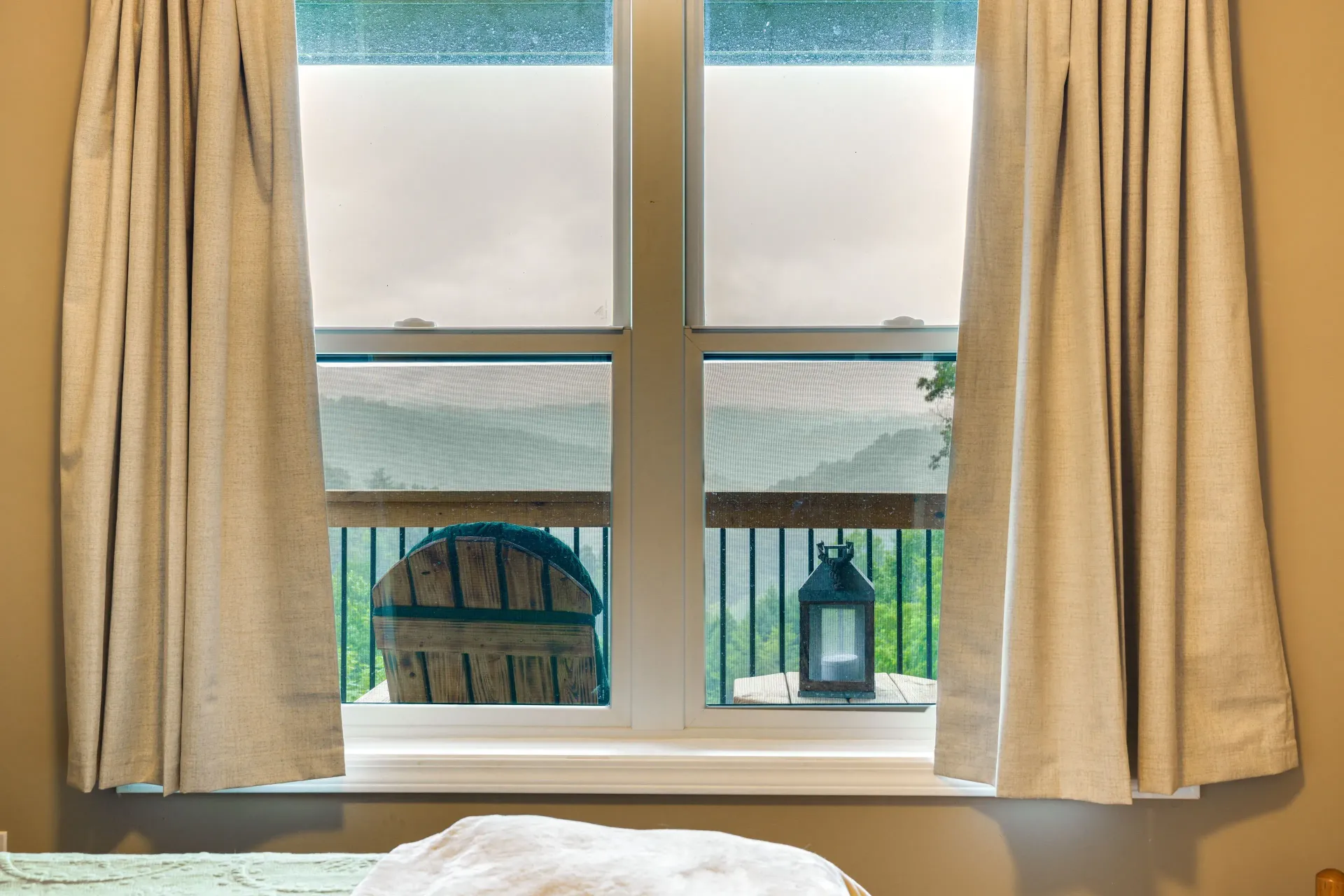 Curtained window with a view of a patio roof and two lanterns outside