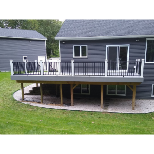 Raised deck on a gray house with black railing and white-trimmed sliding doors in a grassy yard.