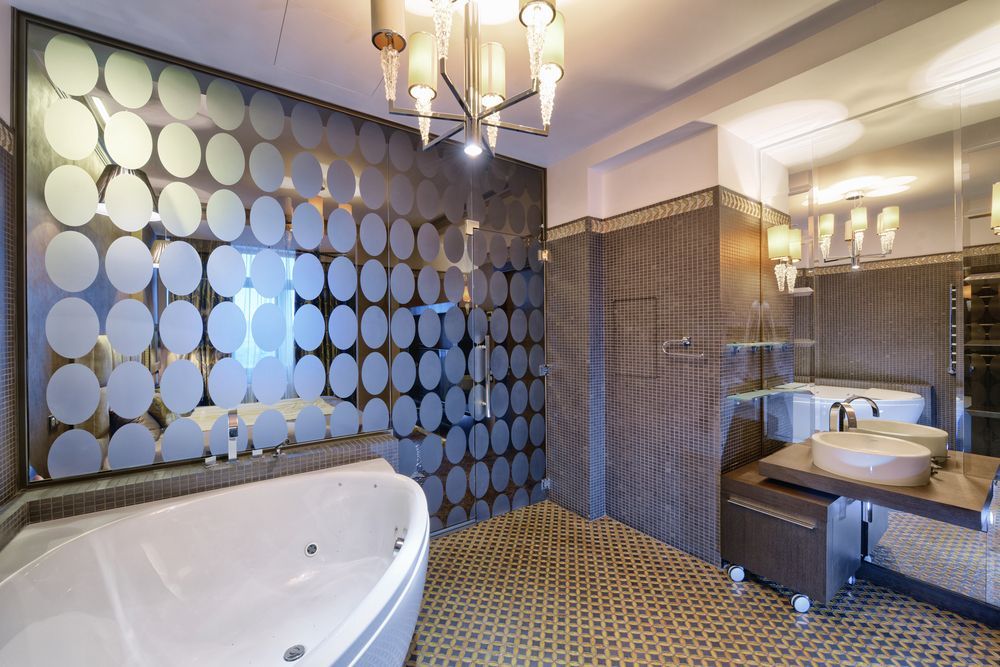 Luxurious bathroom with a jacuzzi, glass-walled shower, patterned wall and flooring, and modern lighting — FNQ Footprints Plumbing In Whitfield, QLD