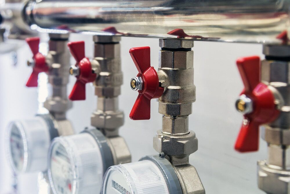 Close-Up of Water Meters with Red Handle Valves and Connecting Pipes — FNQ Footprints Plumbing In Whitfield, QLD