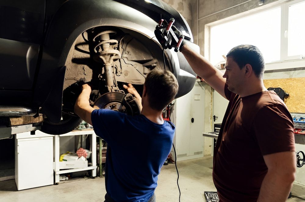 Two Men Are Working On A Car In A Garage — Figtree Brake and Clutch in Fairy Meadow, NSW