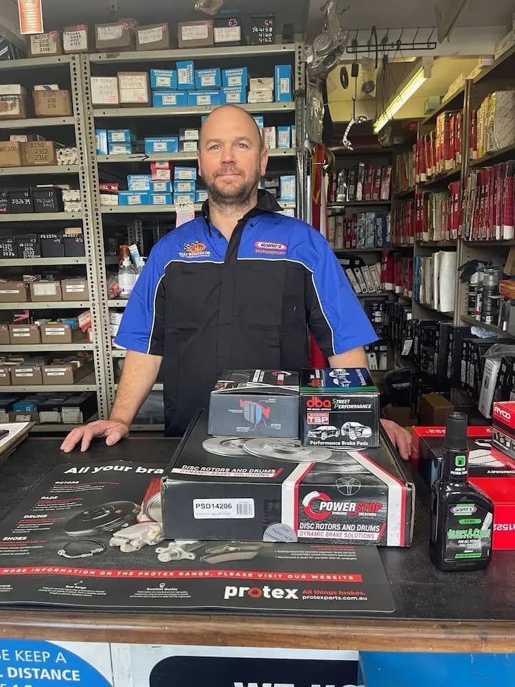 A Man Is Standing In Front Of A Counter In A Store — Figtree Brake and Clutch in Figtree, NSW