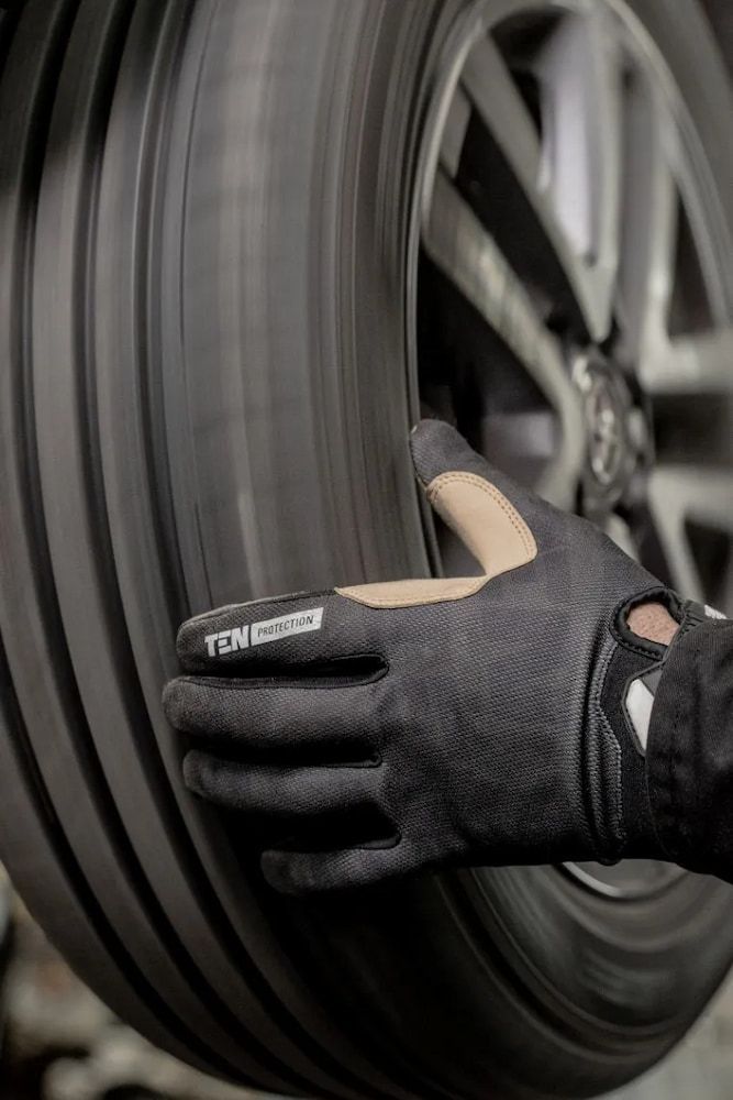 A Person Wearing Gloves Is Holding A Tire In Their Hand — Figtree Brake and Clutch in Figtree, NSW