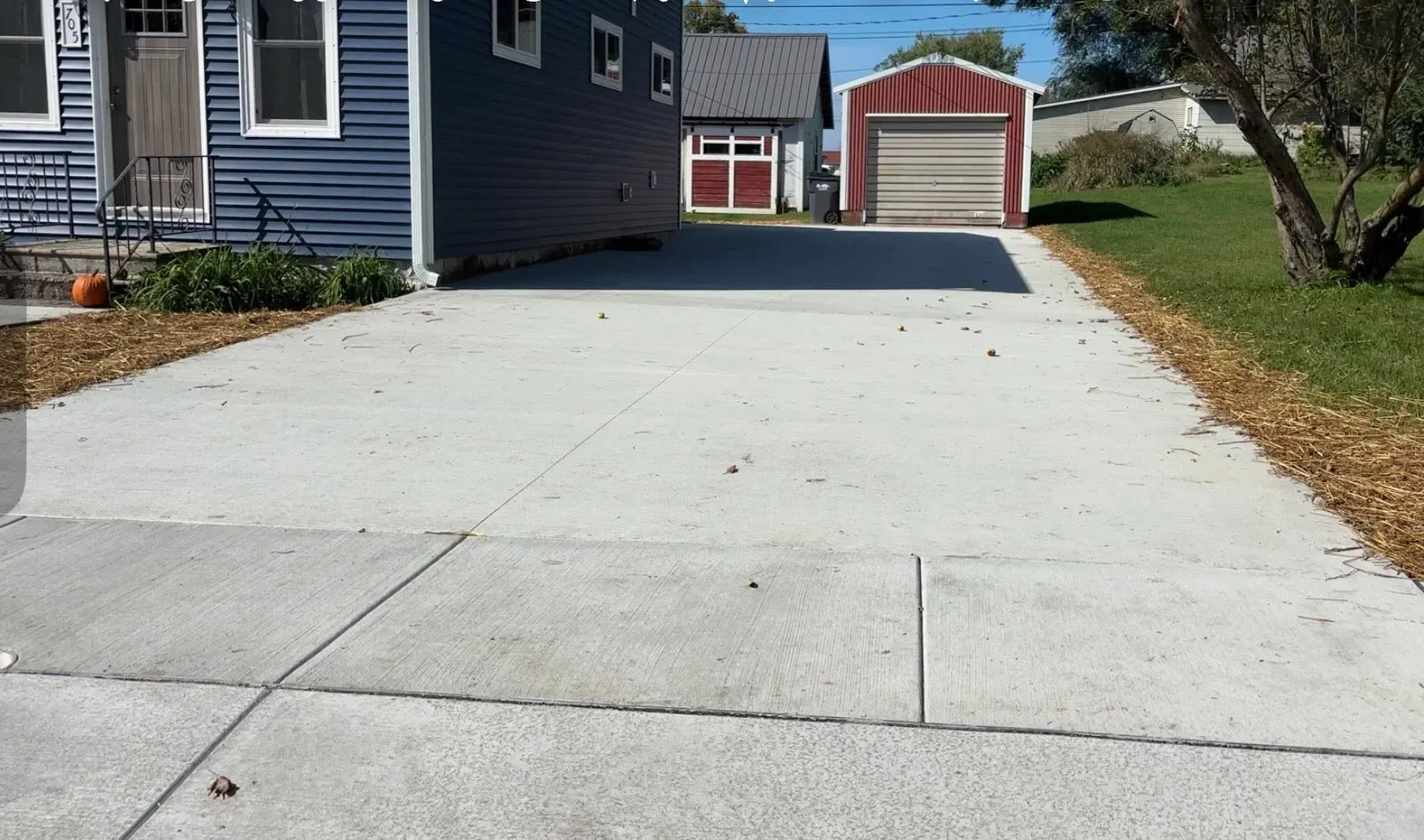 A construction worker in blue gloves uses a mallet to secure pavers into a path.