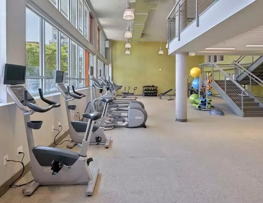 A gym with a lot of exercise equipment and stairs