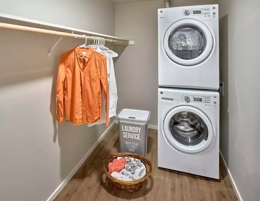 A laundry room with a washer and dryer stacked on top of each other.