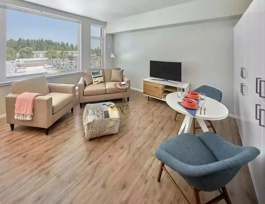 A living room with a couch , chair , table and television.