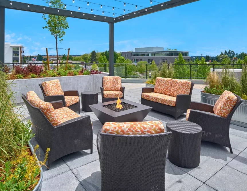 A patio with wicker furniture and a fire pit