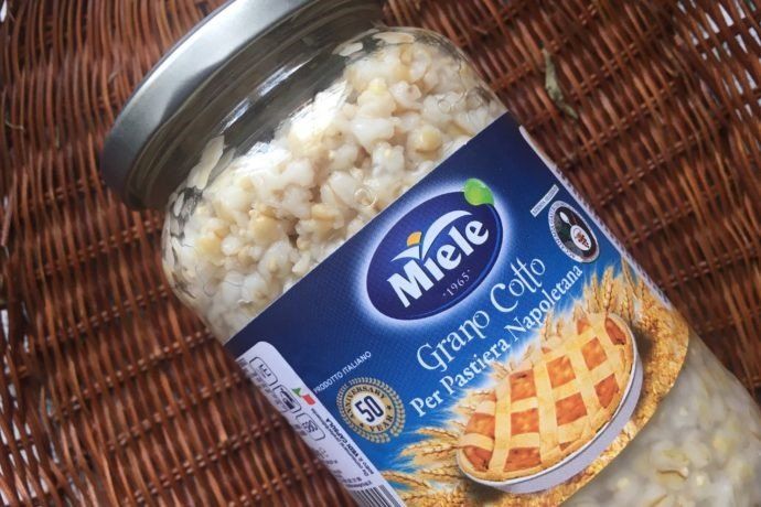 Un barattolo di grano cotto è appoggiato su un tavolo di vimini