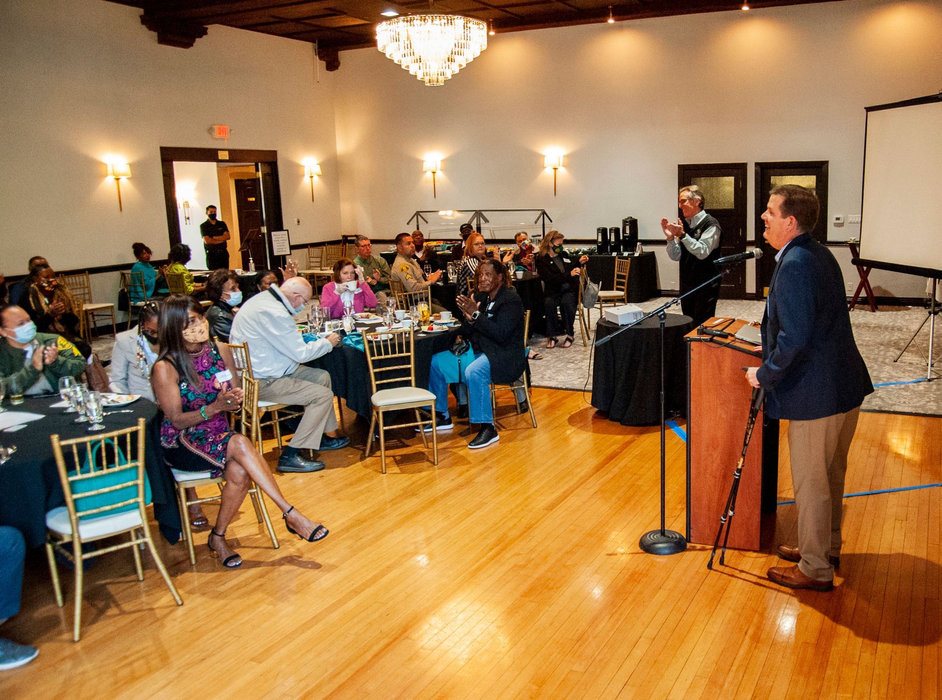 A man stands at a podium in front of a crowd of people