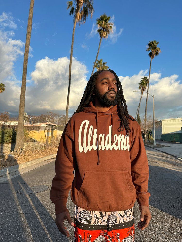 A man is wearing a brown hoodie with the word altadena on it.