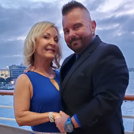A man and a woman are posing for a picture on a cruise ship.