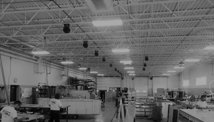 A black and white photo of a factory with people working in it.