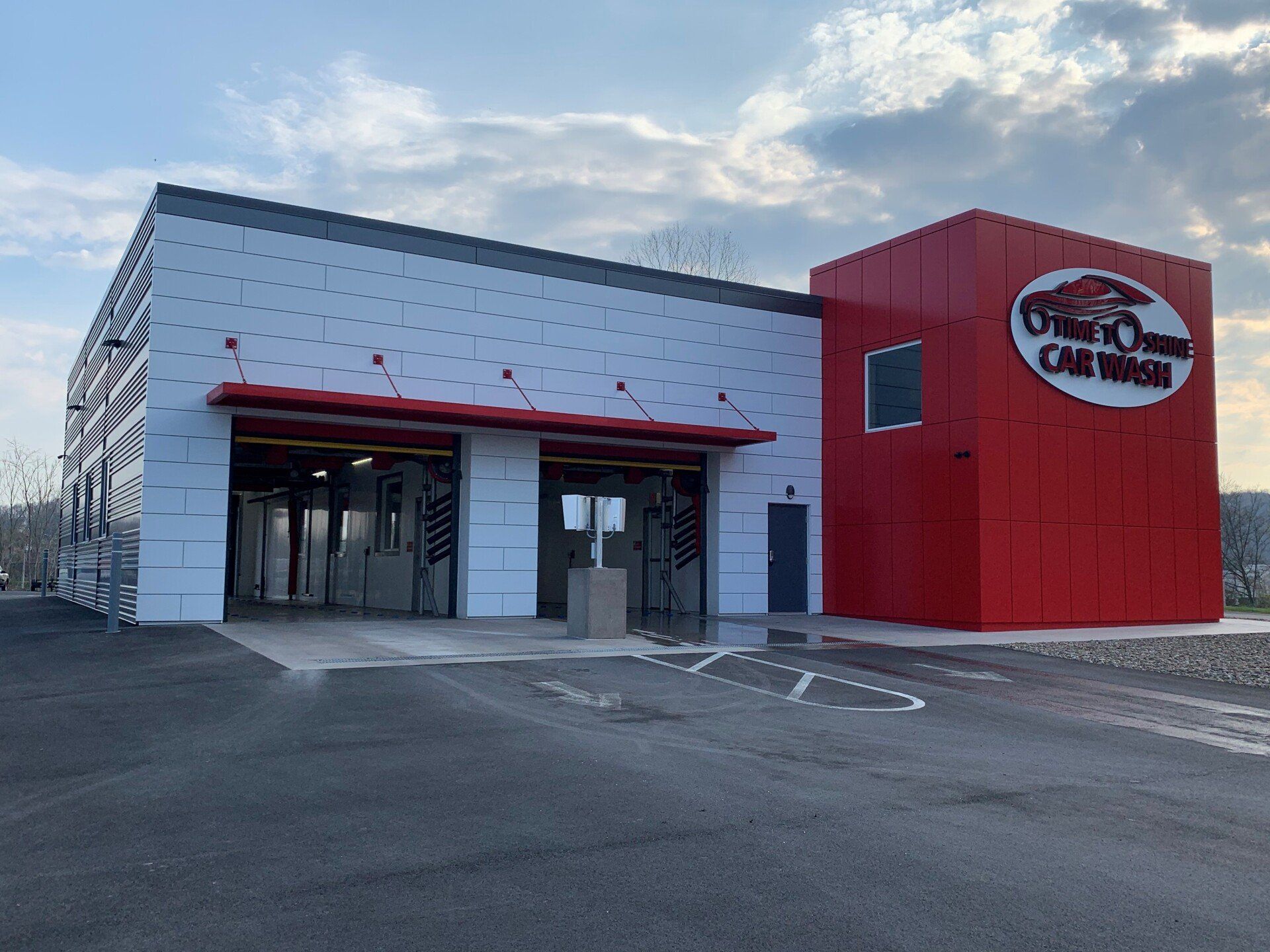 A red and white building with a car wash inside of it.
