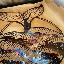 Abstract black bat silhouette over tan fabric with blue and purple beaded trim