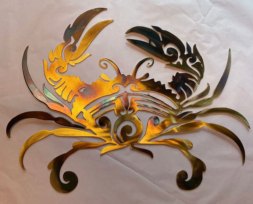 Metallic dragon-like ornamental design in gold, black, and silver on a light background
