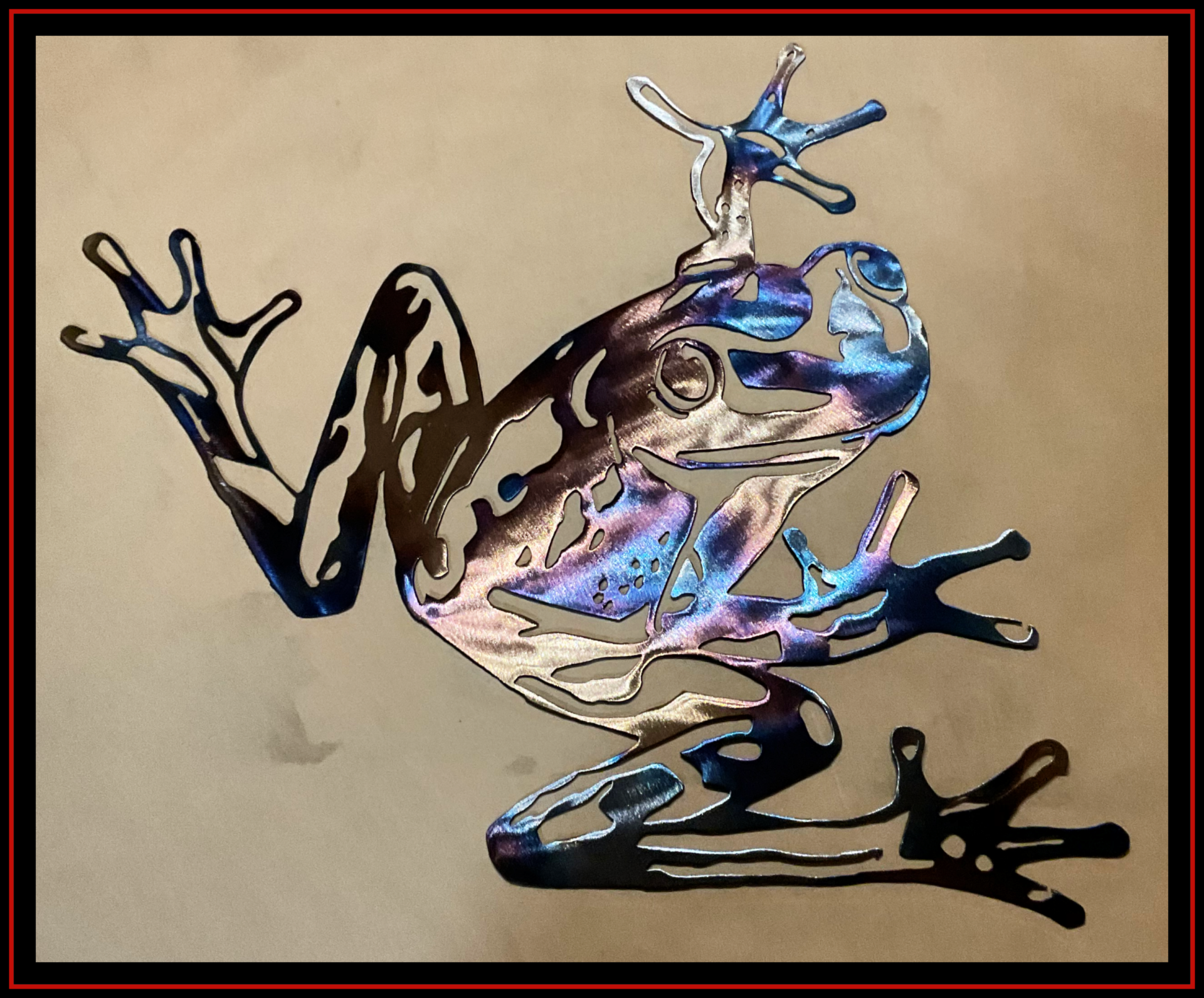 Abstract metallic frog with iridescent blue highlights on a beige background