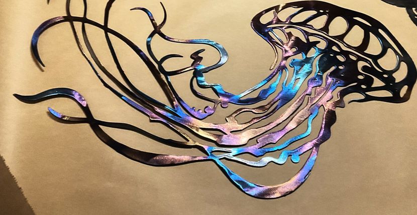 Abstract jellyfish illustration with black tentacles and glowing blue-purple ribbons on a tan background