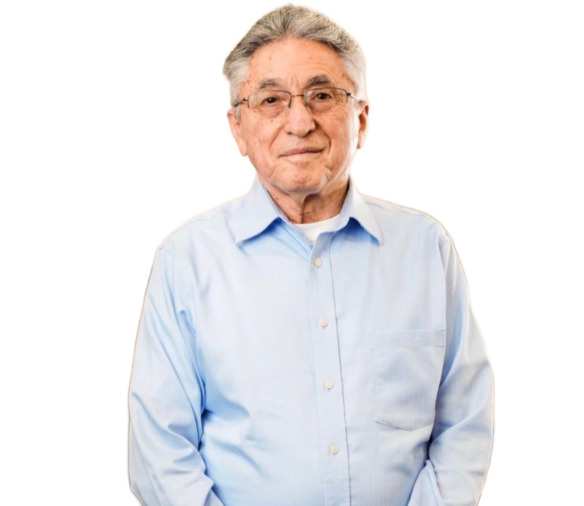 Older man in a light blue shirt standing against a white background