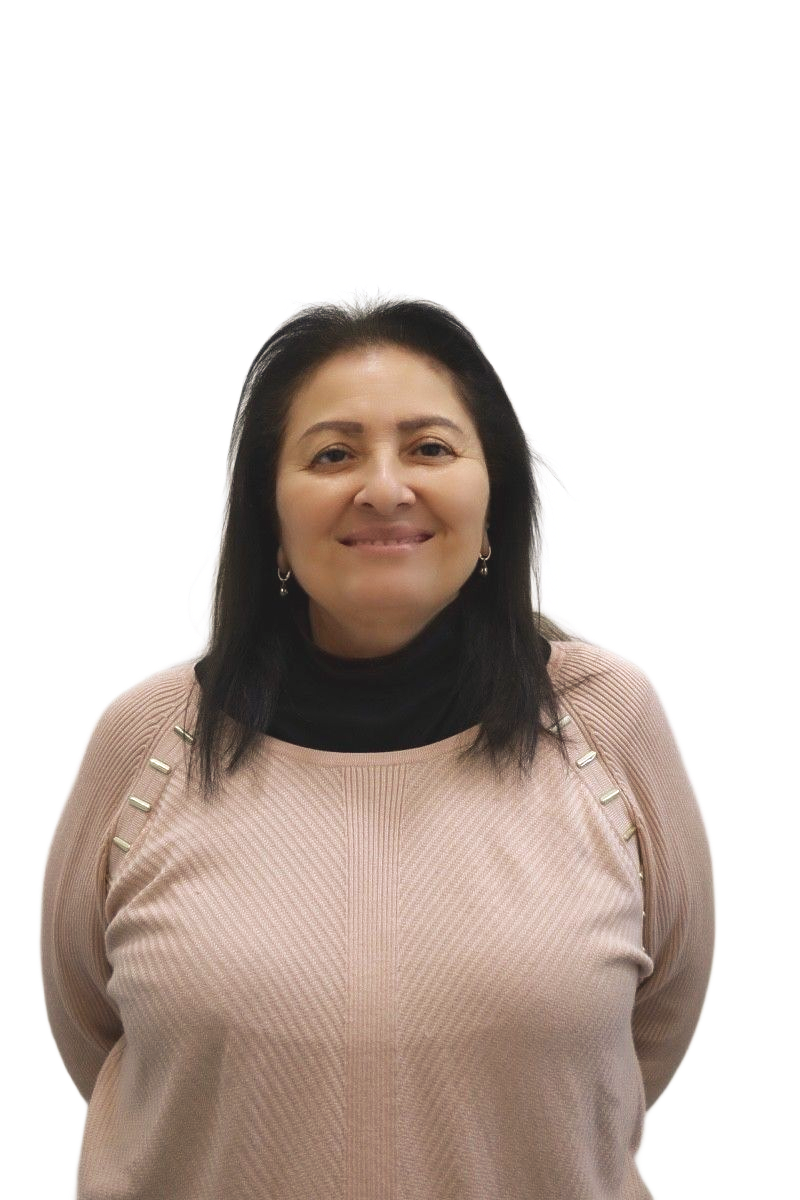Woman in a pink sweater and black turtleneck smiles in front of a white wall.